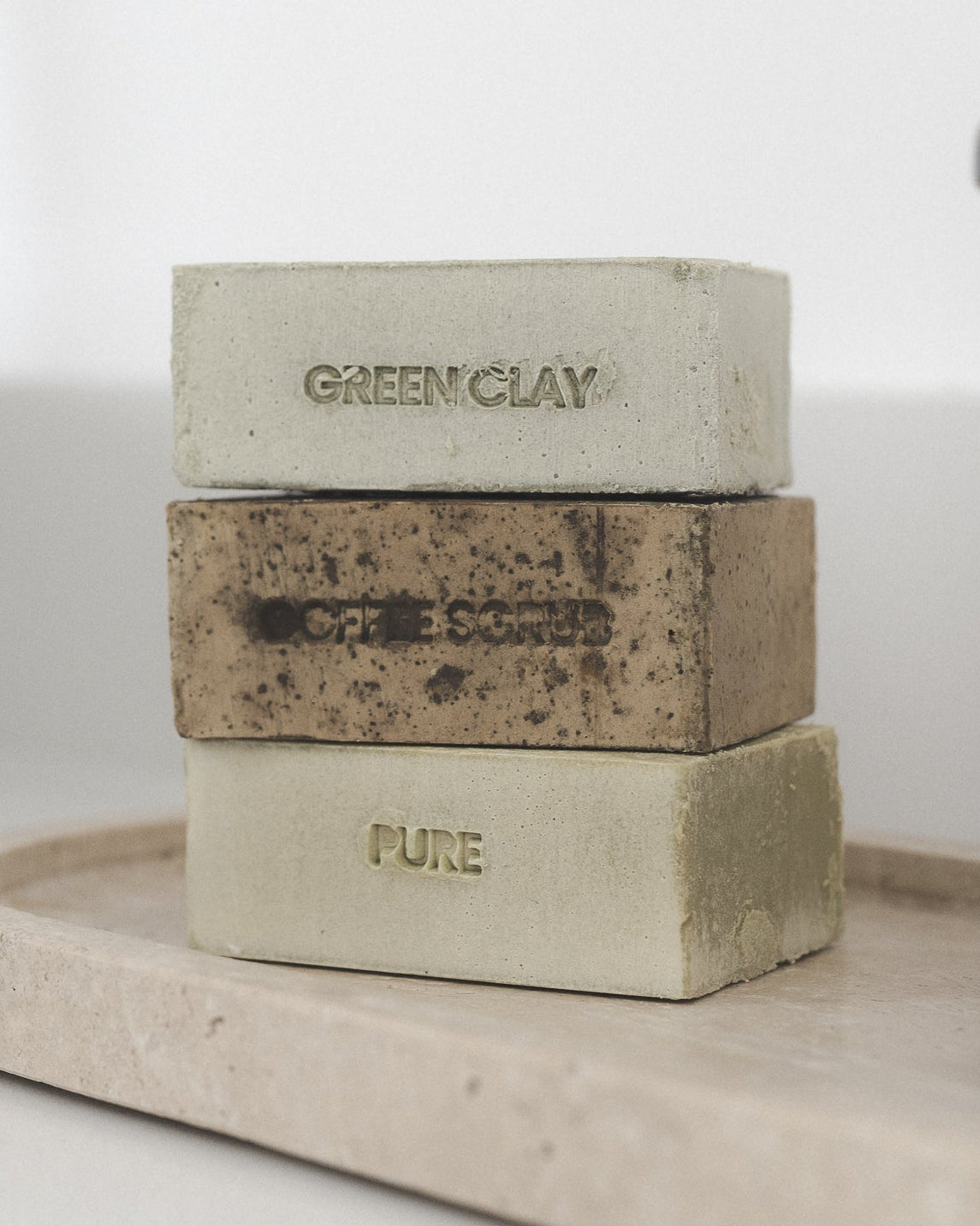 Two The French Kemest soap bars stacked, Coffee Scrub and Pure